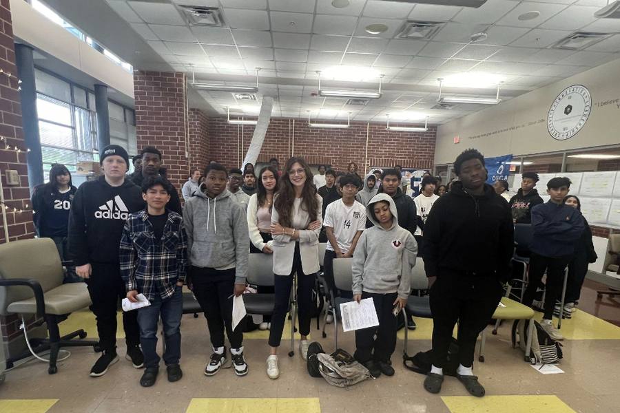 An educator with a class of high school students after a money lesson