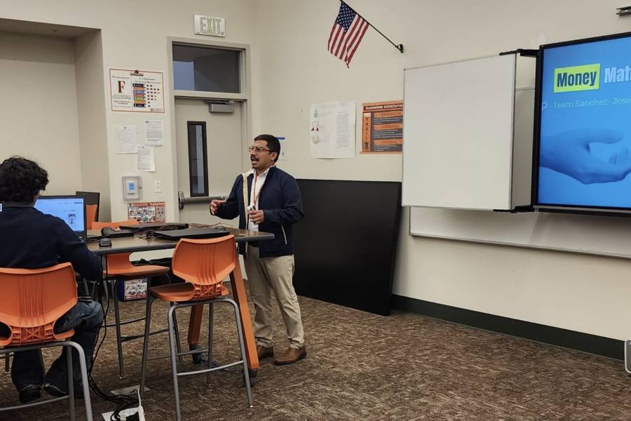 An educator teaching a money class in a high school classroom